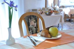 a table with a plate of bread and an apple on it at Hotel Ideal in Sarche di Calavino