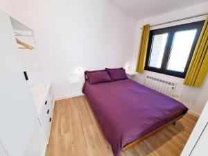 Un pequeño dormitorio con una cama morada en una habitación en Casa Rural Terradets, en Tremp