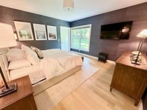 a large bedroom with a bed and a television at Modern 3b3b Country House and Barn on quiet road in Little Compton +17 photos