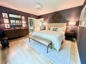 a large bedroom with a large bed and a bench at Modern 3b3b Country House and Barn on quiet road in Little Compton