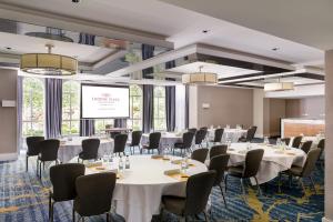 a conference room with tables and chairs and a projection screen at Crowne Plaza Gerrards Cross by IHG in Beaconsfield +138 photos