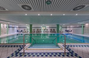 a large swimming pool with chairs in a building at Hotel Aquamarin in Kühlungsborn