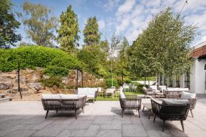 a patio with chairs and tables and trees at Crowne Plaza Gerrards Cross by IHG in Beaconsfield