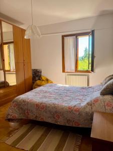 a bedroom with a bed and two windows at Il podere degli ulivi in Santa Veneranda