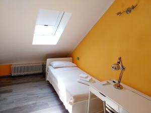 a bedroom with a bed and a desk and a skylight at Casa Palmy in Verbania