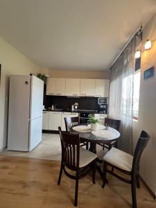 una cucina con tavolo, sedie e frigorifero di Apartment Chocolate Ravda a Ravda