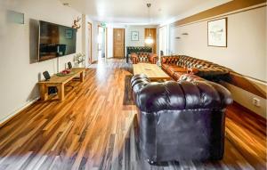 a living room with leather couches and a wooden floor at Nice Apartment In Höör in Höör