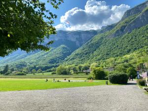 eine Gruppe von Menschen auf einem Feld mit Bergen im Hintergrund in der Unterkunft Maison de village au pied de la montagne in Lumbin