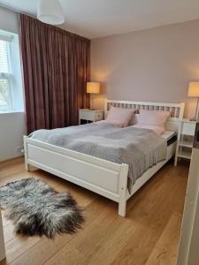 a bedroom with a large white bed with pink pillows at City center, Tórshavn in Tórshavn