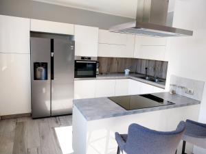 a kitchen with white cabinets and a stainless steel refrigerator at Casa Palmy in Verbania