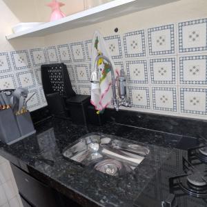 a kitchen counter with a sink in a kitchen at Kitnets a 200 m da praia in Peruíbe
