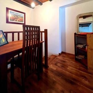 ein Esszimmer mit einem Holztisch und einem Stuhl in der Unterkunft Maison de village au pied de la montagne in Lumbin