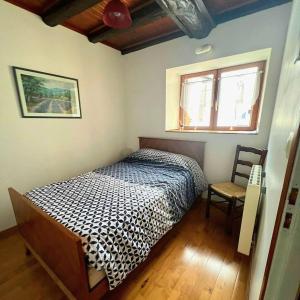 ein Schlafzimmer mit einem Bett und einem Stuhl darin in der Unterkunft Maison de village au pied de la montagne in Lumbin