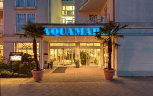 a mall with palm trees in front of a building at Hotel Aquamarin in Kühlungsborn