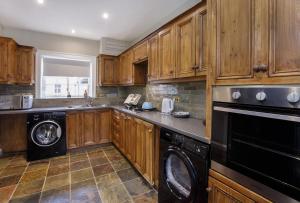 a kitchen with wooden cabinets and a washer and dryer at St Wilfrid's Court in York