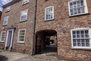 a large brick building with an open gate at St Wilfrid's Court in York