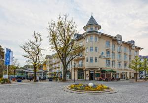 a large building with a tower on a street at Hotel Aquamarin in Kühlungsborn