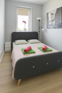 - une chambre dotée d'un grand lit avec des oreillers verts et roses dans l'établissement Urban Jungle - Silver Apartment, à Białystok