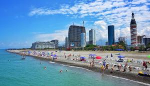 a beach with a bunch of people in the water at Apartment Rustaveli 59 in Batumi