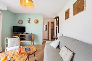 罗克布吕讷-卡普马丹FLOR DE MAYO - Agréable appartement -Proche Mer - Parking Gratuit的客厅里有一张沙发和一张桌子。