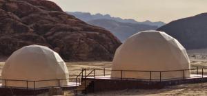 two domes in the desert with mountains in the background at Eram camp in Jurf ad Darāwīsh +10 photos
