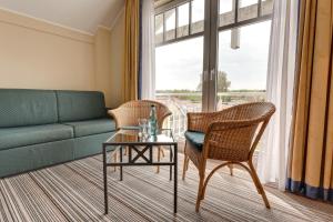 a living room with a couch and chairs and a table at Hotel Aquamarin in Kühlungsborn