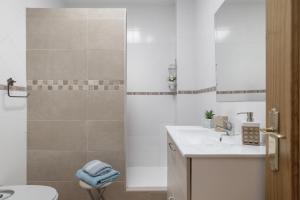 a bathroom with a shower and a sink and a toilet at Apartamento Frank - solo familias in Conil de la Frontera +16 photos