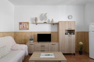 a living room with a couch and a tv at Apartamento Frank - solo familias in Conil de la Frontera