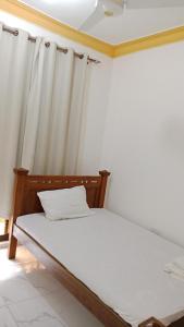 a bed in a room with a curtain at VITU Fine 001 in Mombasa
