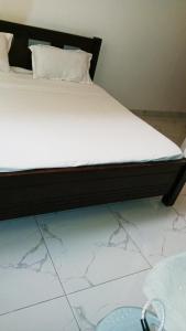 a bed with a black frame and white sheets at VITU Fine 001 in Mombasa