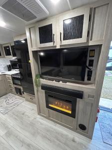 a living room with a fireplace in a kitchen at The Lake Escape RV Meets The Beach in Foley
