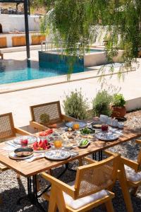 ein Holztisch mit Essen darauf neben einem Pool in der Unterkunft Tulu Datca in Yakaköy + 19 Fotos