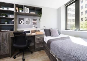 a bedroom with a bed and a desk with a computer at For Students Only - Collegiate Crown Place Cardiff in Cardiff