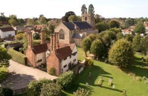 eine Luftaufnahme eines Dorfes mit einer Kirche in der Unterkunft Chelmsford Cottage Homestay Free Parking Fab Garden in Great Waltham