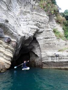 a person is paddling a kayak in a cave at IZU Elysian View in Koura