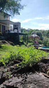 un patio con sombrilla y una casa en Suspiro de Montaña, en La Rancherita