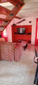 Una sala de estar con un sofá y un televisor de pantalla plana. en Suspiro de Montaña, en La Rancherita