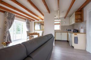 ein Wohnzimmer mit Sofa und eine Küche in der Unterkunft Dalgarnock Cottage in Thornhill