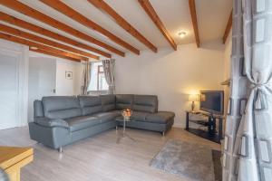 ein Wohnzimmer mit Sofa und Fernseher in der Unterkunft Dalgarnock Cottage in Thornhill