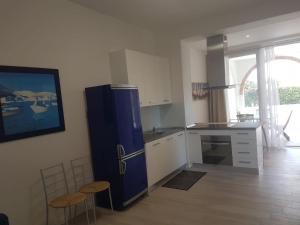 a kitchen with a blue refrigerator and two stools at Golden River n1 Marina di Campo in Campo nell'Elba +10 photos