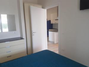 a bedroom with a bed and a mirror and a kitchen at Golden River n1 Marina di Campo in Campo nell'Elba