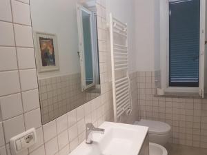 a white bathroom with a sink and a toilet at Golden River n1 Marina di Campo in Campo nell'Elba