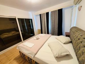 a bedroom with a bed and a large window at Floreasca apartment in Bucharest