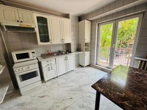a kitchen with white cabinets and a large window at Floreasca apartment in Bucharest