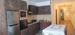 a kitchen with wooden cabinets and a stove top oven at KIAN Apartment in Victoria