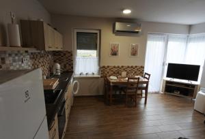 a kitchen with a table and a dining room at Liliom Apartman in Dombóvár