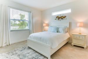 a white bedroom with a bed and a window at 15 Mi to Downtown Fort Myers Golf Getaway in Lehigh Acres