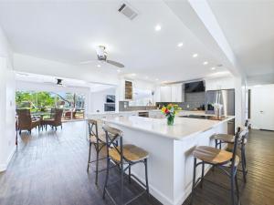 a kitchen with a white counter and some chairs at Dolphins In The Backyard & Rockets In The Sky in Merritt Island