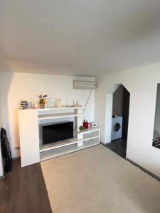 a white living room with a tv and a microwave at City Charm -3 rooms with free Parking in Iaşi