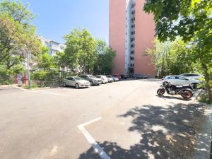a parking lot with a motorcycle parked in front of a building at City Charm -3 rooms with free Parking in Iaşi +3 photos